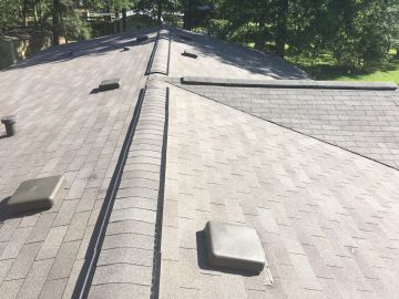 Roof Installation in Buffalo, TX. Three roofers laying new shingle on a roof in Buffalo.